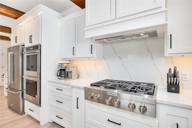 kitchen featuring light hardwood / wood-style flooring, white cabinets, stainless steel appliances, and custom range hood