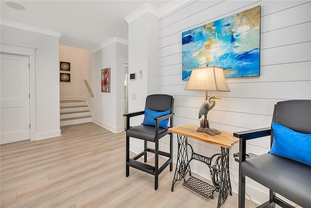 living area featuring light hardwood / wood-style flooring and crown molding