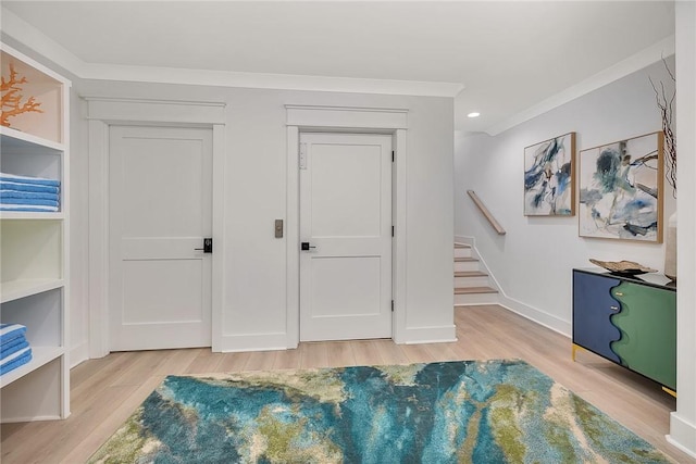 interior space with crown molding and light hardwood / wood-style flooring