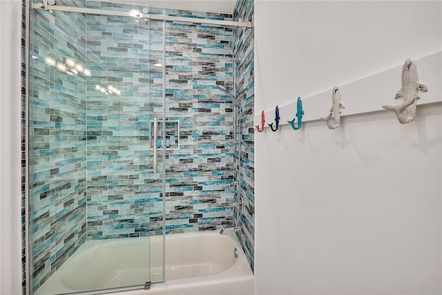 bathroom with bath / shower combo with glass door