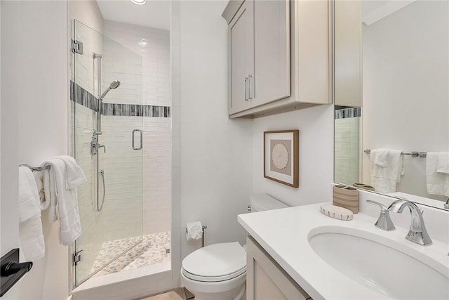 bathroom with vanity, a shower with shower door, and toilet