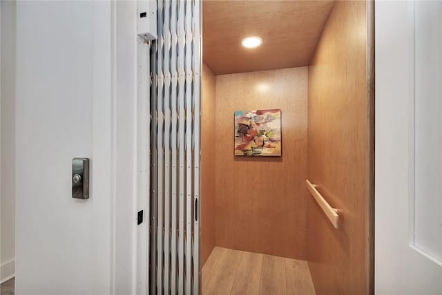 interior details with hardwood / wood-style floors and wooden walls