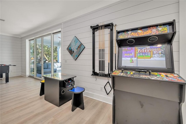 game room featuring wood walls and light hardwood / wood-style flooring