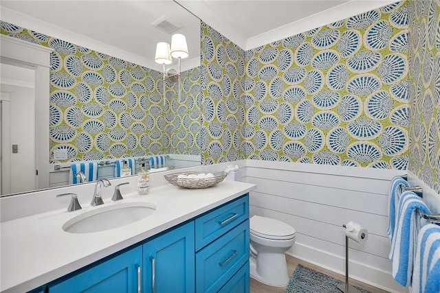 bathroom with vanity, ornamental molding, and toilet