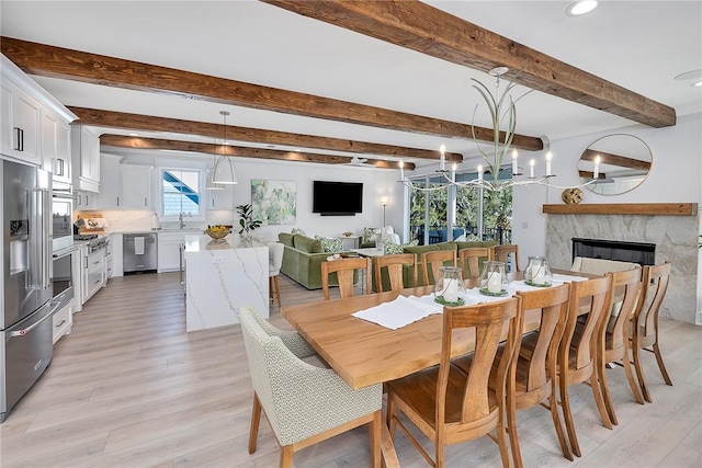 dining room with beam ceiling, light hardwood / wood-style flooring, a notable chandelier, and sink