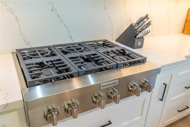 room details featuring white cabinets and stainless steel gas stovetop