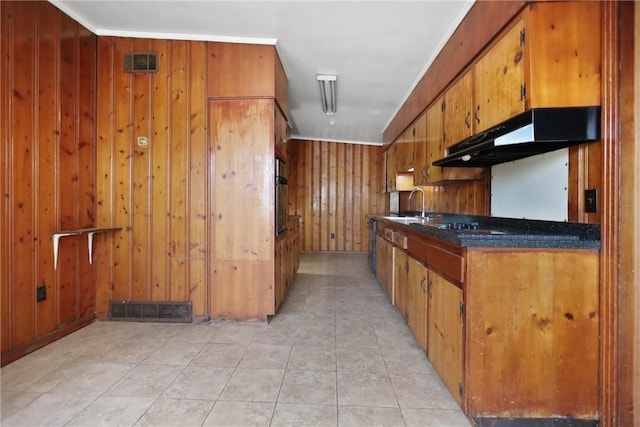4365 US Highway 341, Jesup, GA 31545 - kitchen with brown cabinetry, under cabinet range hood, wood walls, oven, and light tile patterned flooring