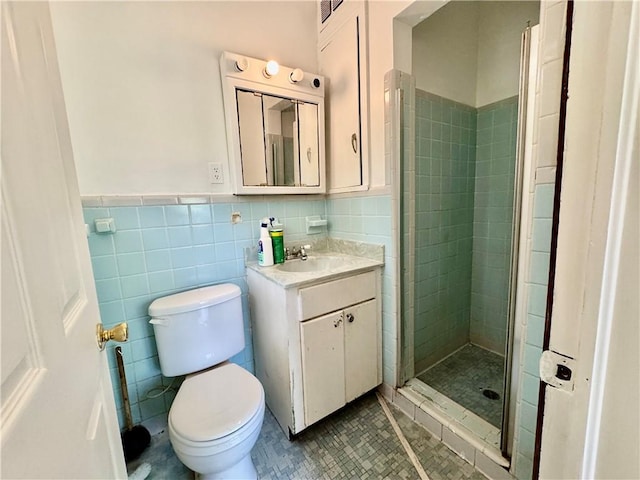 full bathroom featuring vanity, a shower stall, toilet, and tile walls