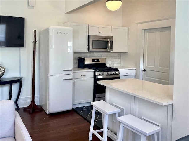 1915 Union St, Brunswick, GA 31520 - kitchen with stainless steel appliances, dark wood-style flooring, light countertops, tasteful backsplash, and white cabinetry