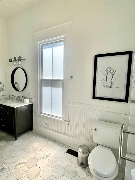 1915 Union St, Brunswick, GA 31520 - bathroom with healthy amount of natural light, a wainscoted wall, tile patterned floors, and toilet