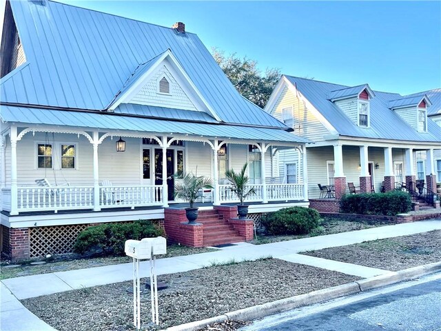 1915 Union St, Brunswick, GA 31520 - view of front of house featuring a porch, a chimney, and metal roof
