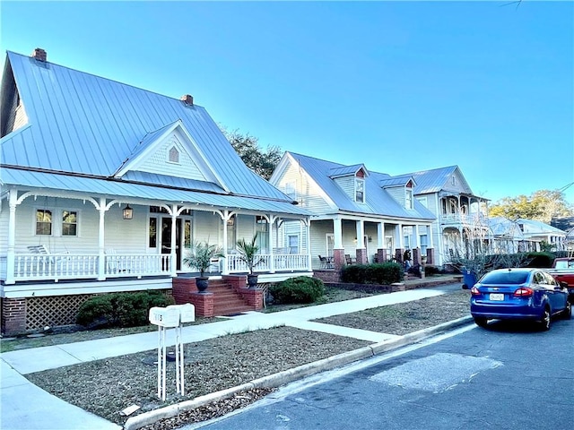 1915 Union St, Brunswick, GA 31520 - view of front of home with covered porch, metal roof, and a chimney