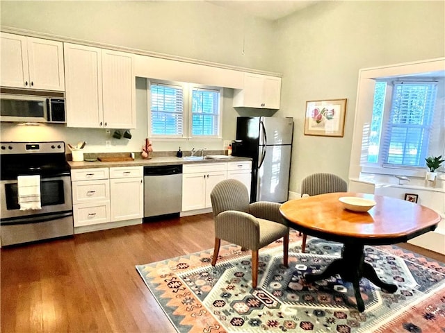 1915 Union St, Brunswick, GA 31520 - kitchen featuring appliances with stainless steel finishes, wood finished floors, white cabinetry, and a sink