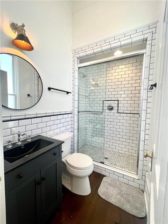 1915 Union St, Brunswick, GA 31520 - bathroom featuring wood finished floors, a stall shower, tile walls, toilet, and vanity