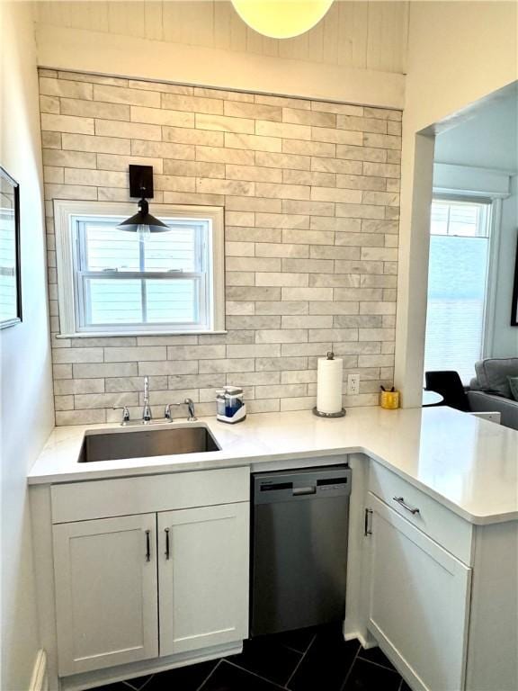 1915 Union St, Brunswick, GA 31520 - kitchen featuring a sink, dishwashing machine, decorative backsplash, and light countertops