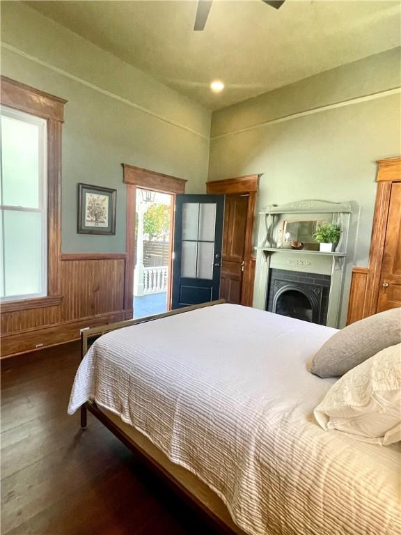 1915 Union St, Brunswick, GA 31520 - bedroom with wood finished floors, wainscoting, a ceiling fan, access to outside, and wood walls