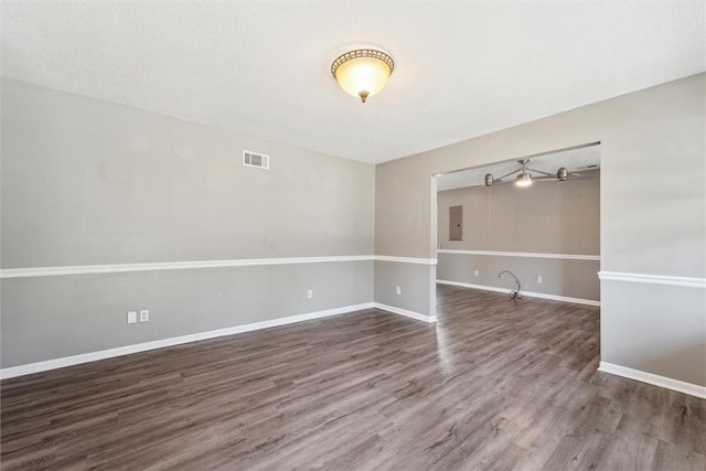 spare room with visible vents, baseboards, and wood finished floors