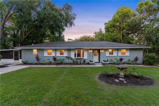 3120 Willow Ave, Brunswick, GA 31520 - single story home with brick siding, a yard, and a sunroom