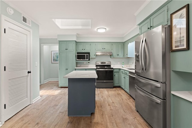 3120 Willow Ave, Brunswick, GA 31520 - kitchen with stainless steel appliances, under cabinet range hood, crown molding, light countertops, and light wood finished floors