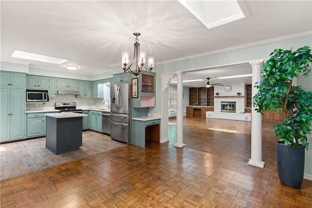 3120 Willow Ave, Brunswick, GA 31520 - kitchen with appliances with stainless steel finishes, under cabinet range hood, ornate columns, light countertops, and a sink