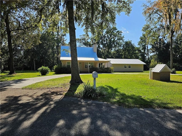 146 Don El St, Brunswick, GA 31523 - view of front of home with a front lawn, curved driveway, and a metal roof
