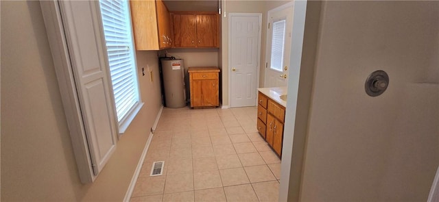 146 Don El St, Brunswick, GA 31523 - laundry room featuring cabinet space, water heater, and light tile patterned floors