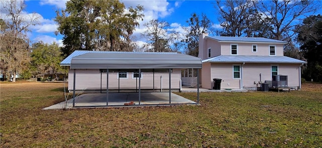 146 Don El St, Brunswick, GA 31523 - back of house with a detached carport, a metal roof, a chimney, a lawn, and a patio area