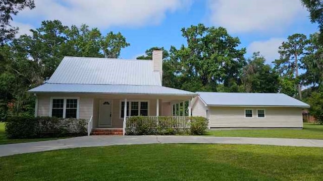 146 Don El St, Brunswick, GA 31523 - farmhouse-style home with covered porch, a front yard, a chimney, and concrete driveway
