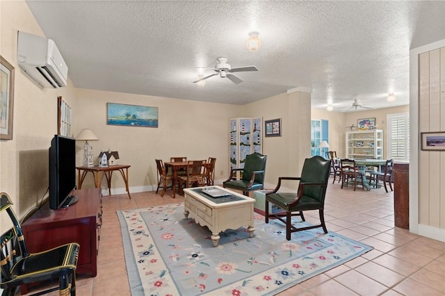 living room featuring ceiling fan, light tile patterned floors, a textured ceiling, a wall unit AC, and baseboards