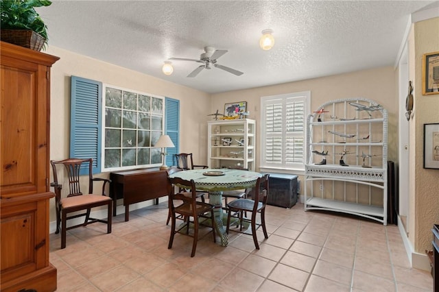 dining room featuring light tile patterned floors, ceiling fan, and a textured ceiling