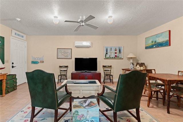 living area with a ceiling fan, a wall unit AC, a textured ceiling, and light tile patterned floors