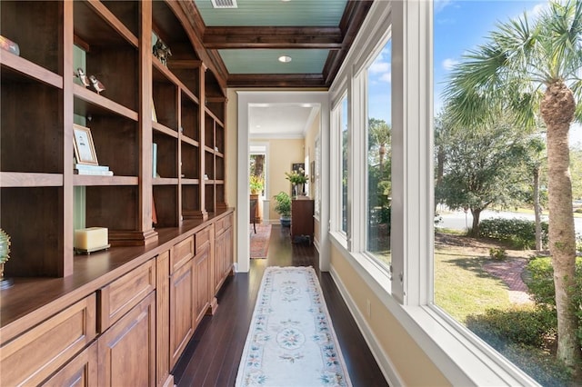 hall featuring baseboards, coffered ceiling, dark wood-type flooring, beamed ceiling, and crown molding