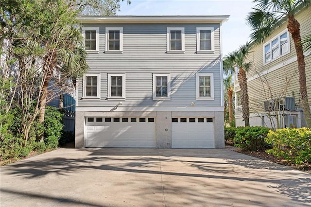 view of front of property with driveway, central AC unit, an attached garage, and stucco siding