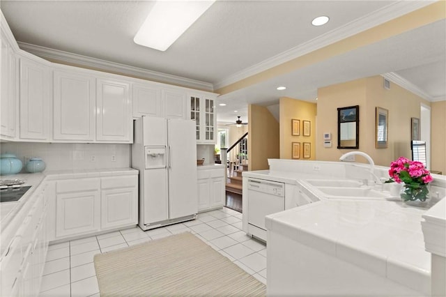 kitchen featuring ornamental molding, white appliances, white cabinetry, and a sink