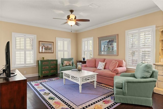 living area with baseboards, a ceiling fan, dark wood-style flooring, and crown molding