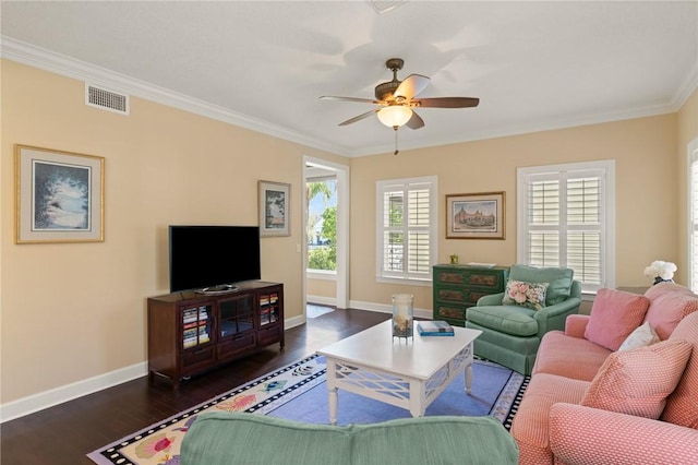 living room featuring dark wood finished floors, visible vents, ornamental molding, ceiling fan, and baseboards