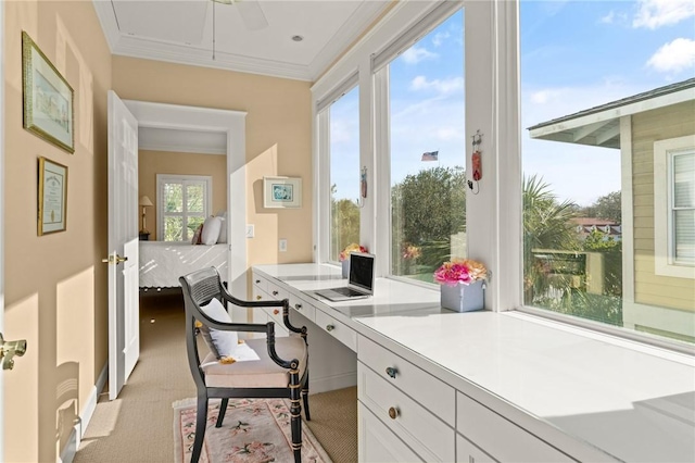 home office featuring light colored carpet, crown molding, and built in study area