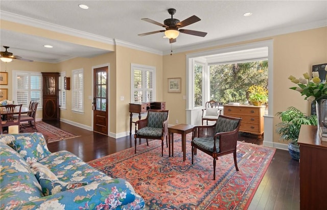 living area with hardwood / wood-style flooring, a wealth of natural light, and crown molding