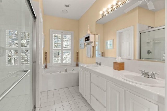 full bathroom with a stall shower, tile patterned flooring, a sink, and a bath