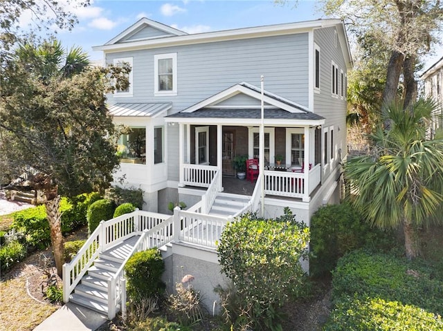 view of front of home featuring covered porch and stairs