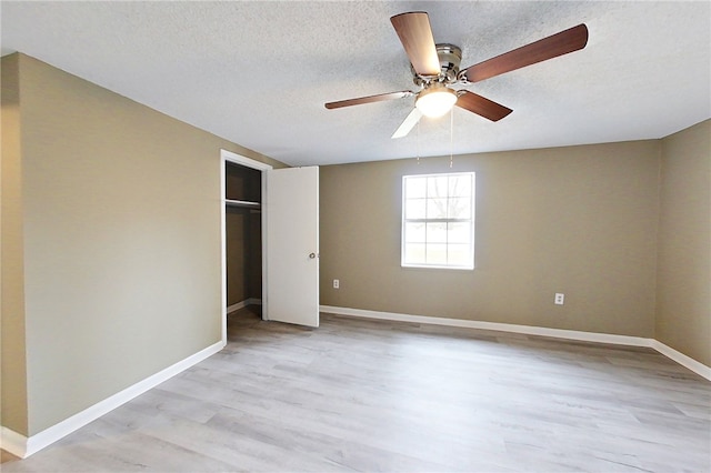 unfurnished bedroom with light wood-style flooring, baseboards, and a textured ceiling