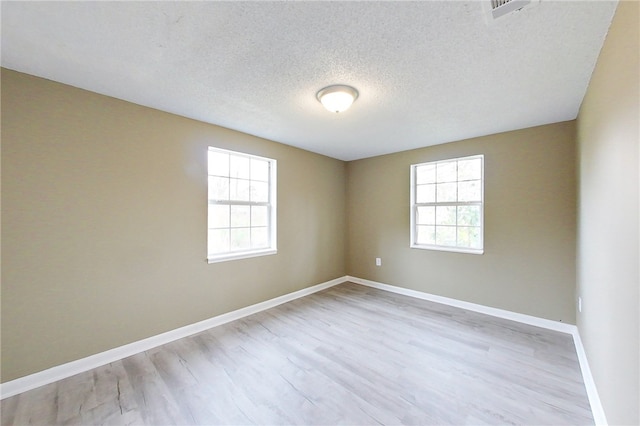 unfurnished room with plenty of natural light, baseboards, and light wood-style flooring