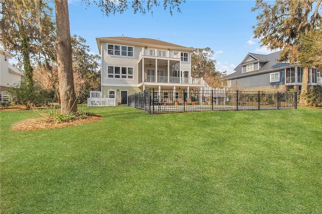 rear view of property featuring a balcony, stairway, fence, a yard, and a sunroom