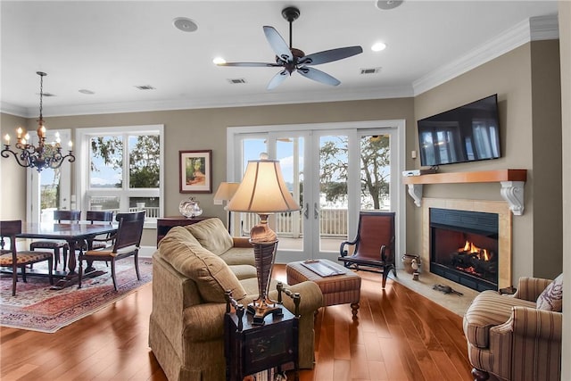 living area featuring a healthy amount of sunlight, ornamental molding, and hardwood / wood-style floors