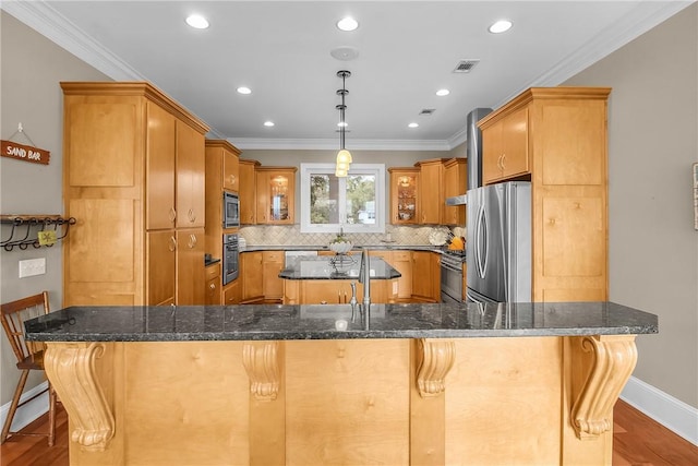 kitchen with a kitchen island, visible vents, stainless steel appliances, and crown molding