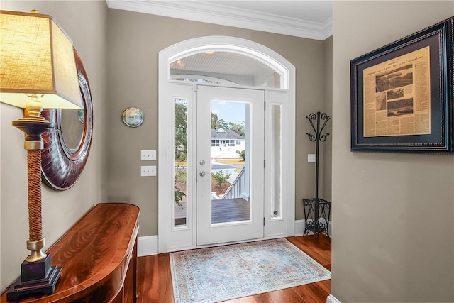 entryway featuring wood finished floors, baseboards, and ornamental molding