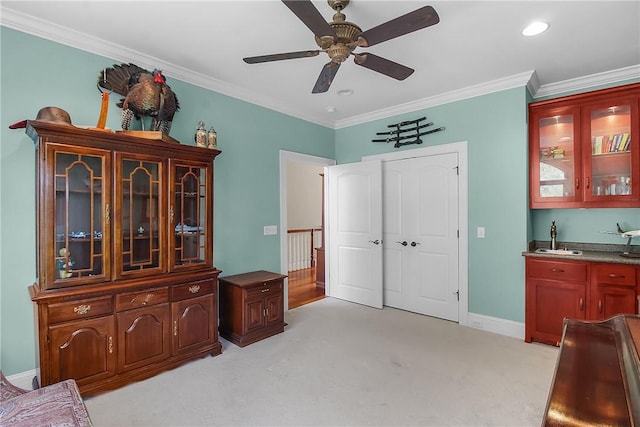 living area with light carpet, ornamental molding, a ceiling fan, indoor wet bar, and baseboards