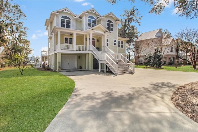 coastal home with stairway, driveway, a porch, and a front yard