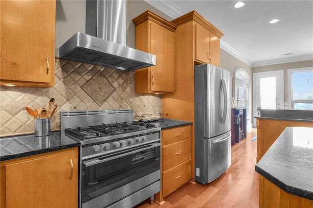 kitchen with light wood-type flooring, backsplash, appliances with stainless steel finishes, crown molding, and wall chimney range hood