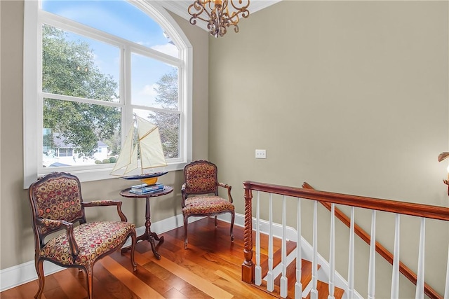 living area featuring baseboards, stairs, an inviting chandelier, and wood finished floors